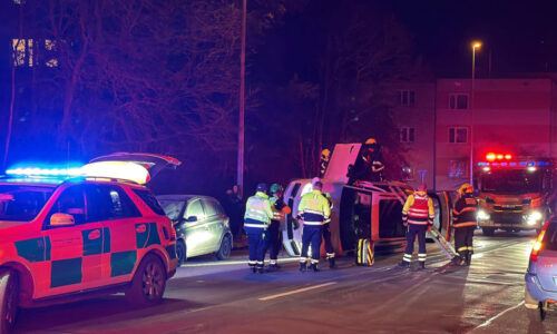 Porsche v Praze skončilo převrácené na boku. Řidič naboural zaparkované auto, utrpěl zranění